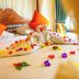 Hotel Deli River and Restaurant Omlandia in Medan: swan towel display with flower petals on a bed