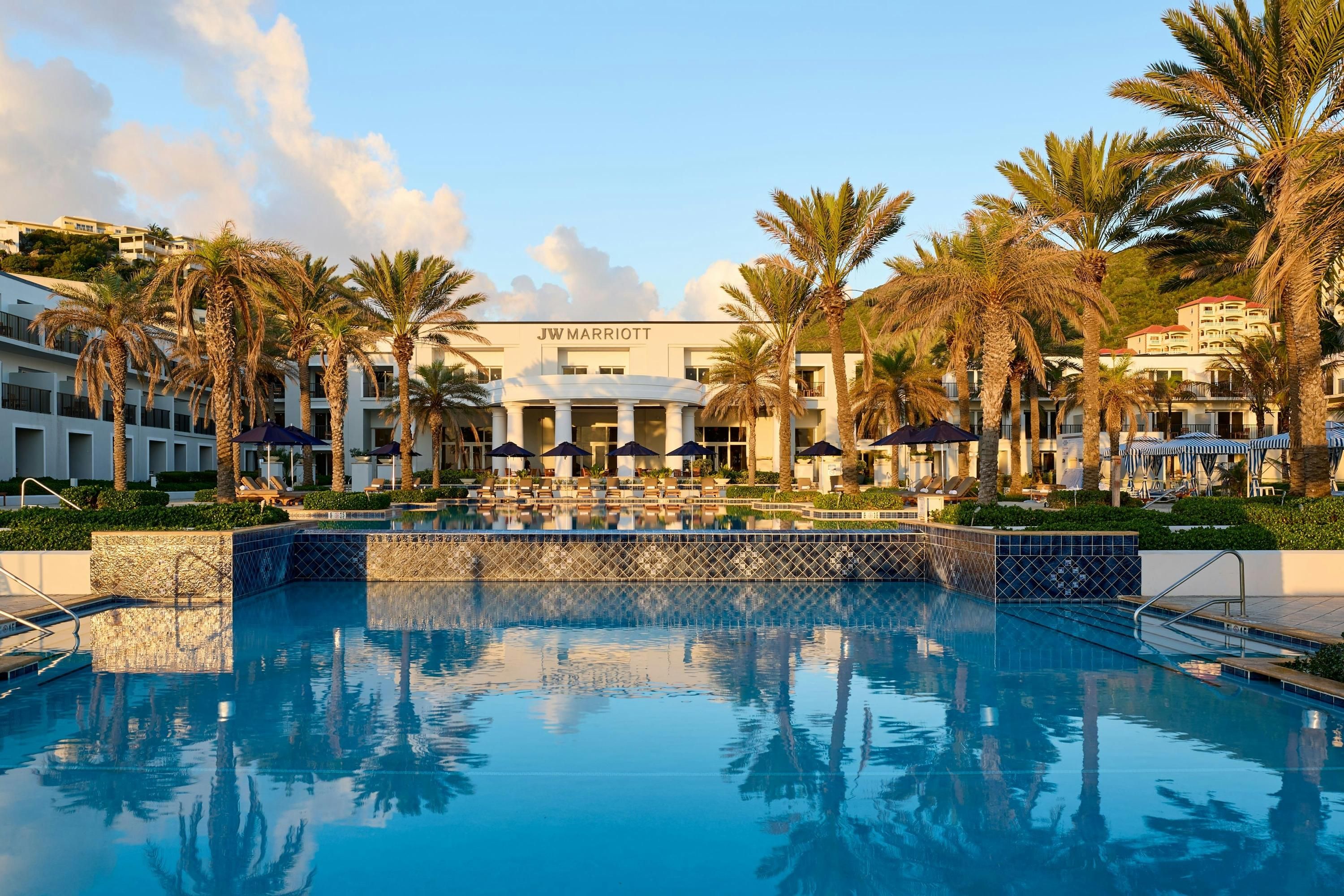 JW Marriott St. Maarten Beach Resort & Spa pool with palm trees and oceanfront resort buildings in Upper Prince's Quarter