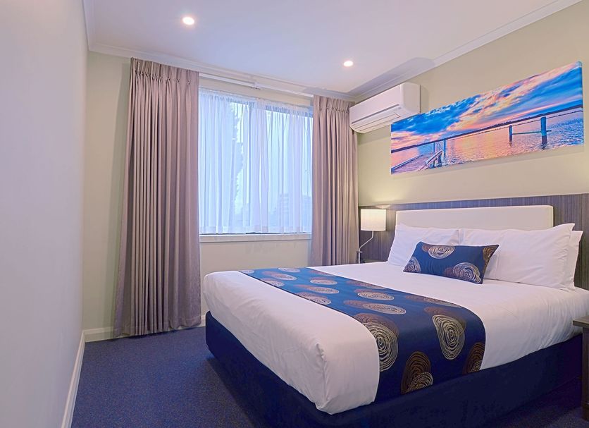 Park Squire Motor Inn & Serviced Apartments Melbourne guest room with queen bed, window and wall art