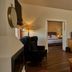 Xenia Palace Portarias room with fireplace, armchair, TV, desk, and bedroom visible through open doorway in Portaria.
