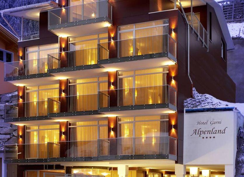 Hotel Alpenland in Sankt Anton am Arlberg with illuminated balconies and snowy alpine exterior