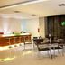 Lobby dining area at Hotel Glodok Plaza in Jakarta with tables, chairs and a lit bar