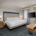 Homewood Suites by Hilton Bonita Springs Naples North guest room with king bed, TV and sitting area