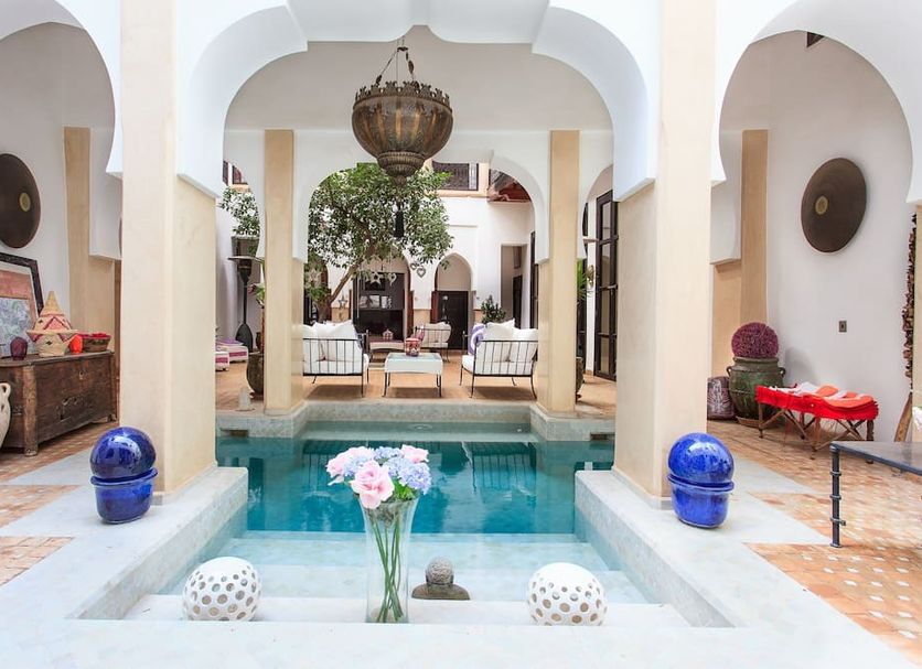 Dar Charkia Marrakech courtyard with central pool, arched walkways, and hanging lantern