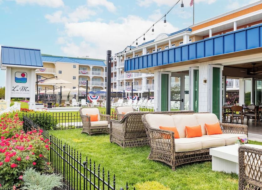 La Mer Beachfront Resort in Cape May with a seaside patio, wicker seating, and ocean-view lawn