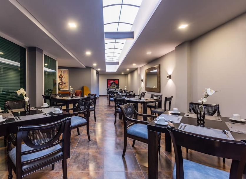 Hotel Egina Medellin dining room with set tables and skylight in Medellín