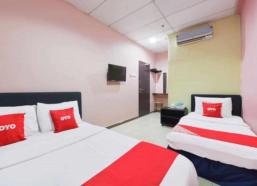 Hotel O Destiny Riverside Hotel room in Kota Bharu with two beds, wall-mounted TV and air conditioner