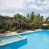 Tanjung Alam Hotel in Buleleng with a tropical outdoor pool, palm trees, and ocean view