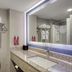 SureStay by Best Western Greenville bathroom with vanity sink, wall mirror, towels, and toilet