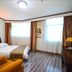 Orange Crystal Hotel Xuzhou Suning Plaza room with bed, armchair, desk, and two large windows