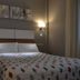 Hotel Playa Compostela room with double bed, wall sconces, and patterned bedspread in Vilagarcía de Arousa