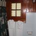 Evening Shade River Lodge & Cabins bathroom with wood-paneled walls, window, towels, and white tile in Chimney Rock