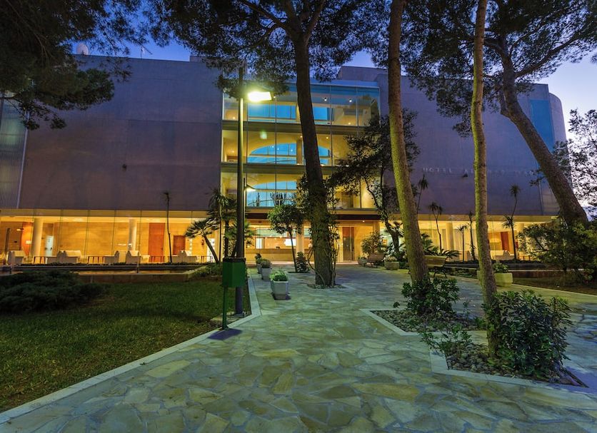 Zafiro Alzinar Mar in Can Picafort, exterior at dusk with lit balconies, trees, and garden walkway