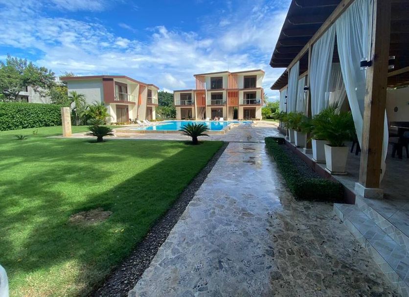 Caribbean Diamond Boutique Hotel in Sosúa with pool, lawn, and outdoor terrace under blue sky
