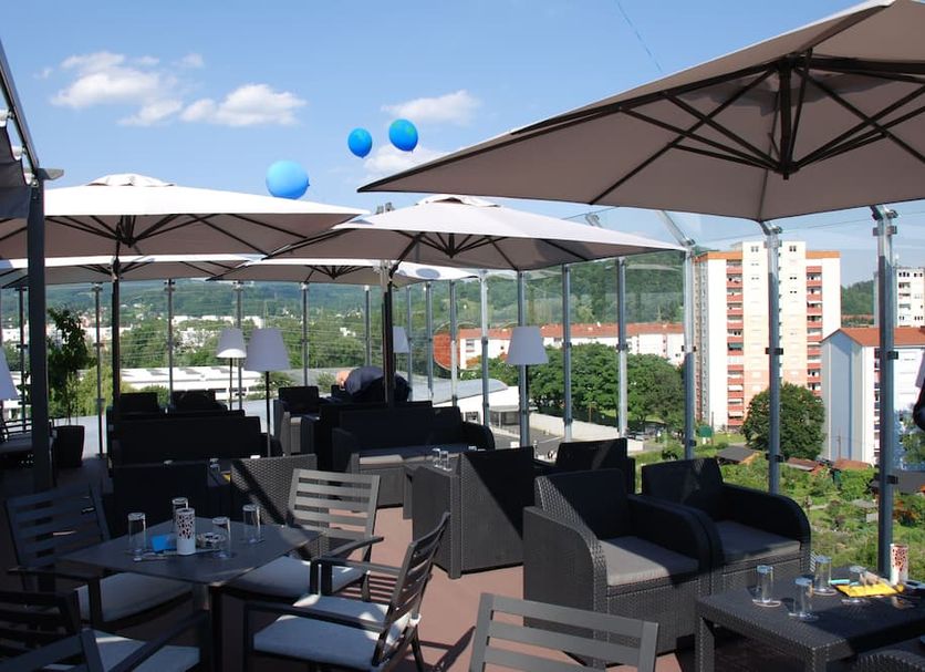 Novapark Das Flugzeughotel rooftop terrace in Graz with city views, umbrellas and lounge seating