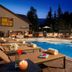 The Osprey at Beaver Creek pool deck at dusk with lounge chairs and mountain backdrop