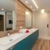 Marketplace Suites in St. John bathroom with double sink vanity, walk-in shower, and wood-look flooring