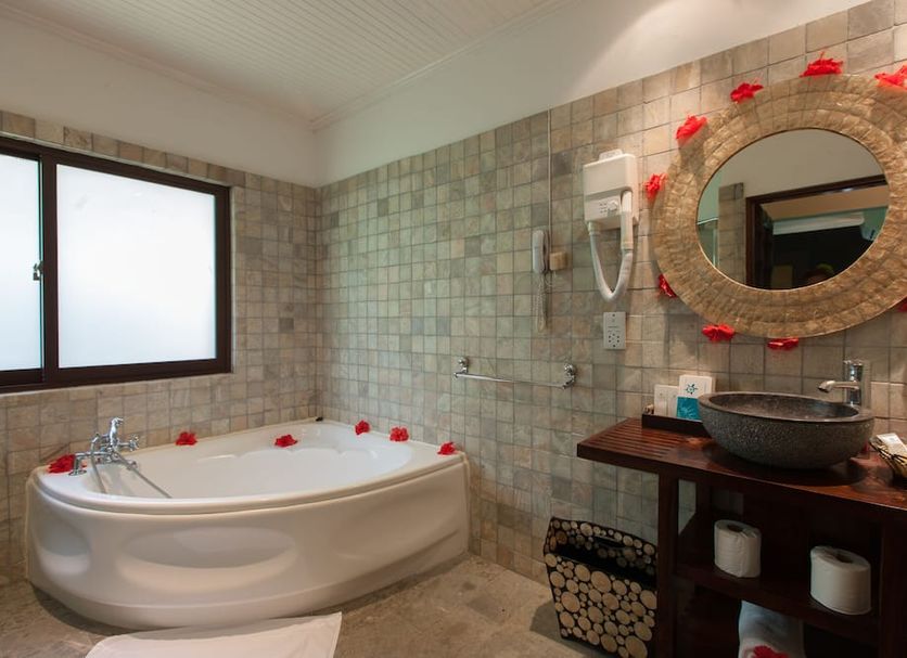 Le Relax Beach Resort Grand'Anse Praslin bathroom with soaking tub, vessel sink and mirror