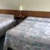 Village Green Motel South Yarmouth room with two double beds and bedside lamp