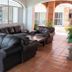 La Joya Del Lago in Ajijic lobby with leather sofas, coffee table, terracotta tile floor, and courtyard view
