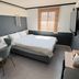 Hotel Atti Incheon guest room with double bed, desk, wall-mounted TV and window blinds