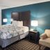 Motel 6 Crowley, La guest room with king bed, lamps, and upholstered chair in Crowley