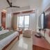 OYO 1790 Hotel Raj Mandir Haridwar room with king bed, TV, seating area and city-view window