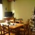 Hotel Meublè Adler room with wooden dining table, TV, and stone fireplace in Santa Caterina Valfurva