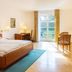 Churfuerstliche Waldschaenke guest room in Moritzburg with bed, desk, TV, and French doors to greenery