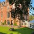 Cringletie House Hotel in Peebles, red-brick manor with manicured lawn and picnic table