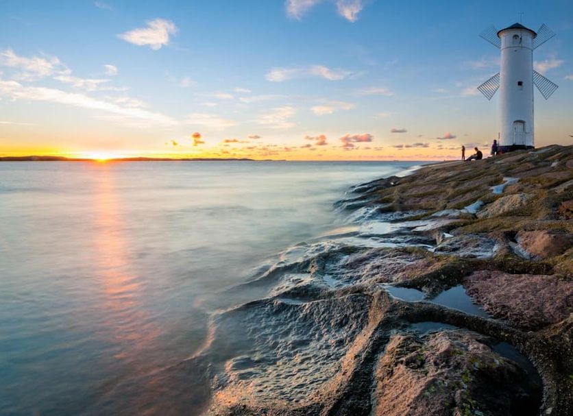 Graal Spa in Świnoujście with seaside lighthouse view at sunset and rocky shoreline