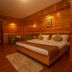 Hotel Jagjeet, Darjeeling wood-paneled guest room with double bed, bedside lamps and rug