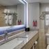 SureStay by Best Western Greenville bathroom with vanity, sink, mirror, toilet, and tiled shower area