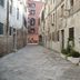 Cà Furlan in Venice, narrow stone alley beside historic buildings and potted plants