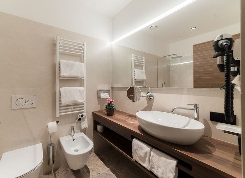 Hotel Stiegl Scala bathroom in Bolzano with vessel sink, bidet, wall-mounted toilet and heated towel rack