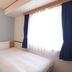Toyoko Inn Niigata Ekimae guest room with a single bed and large window with blue curtains in Niigata