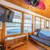 Nantahala Cabins in Bryson City cabin interior with couch, TV, kitchen, and windows overlooking a hot tub
