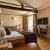 Hotel Porta San Mamolo Bologna guest room with canopy bed, desk, and window curtains