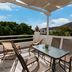Cyclades Beach Apartments in Platis Gialos: terrace with table, chairs, and hillside view