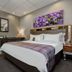 Anew Hotel Hatfield Pretoria guest room with king bed, purple floral wall art and wardrobe in Pretoria