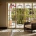 The Danai, Nikiti: sunlit lounge with wicker chair and garden-view French doors