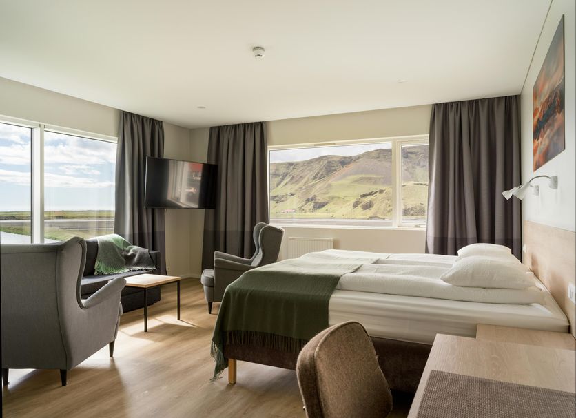 Hotel Katla by Keahotels room in Vik with twin beds and large windows overlooking hills