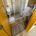 Pousada Fortaleza in Paraty bathroom with glass shower, toilet, sink, and yellow door