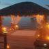 Come Friday Cottages on the Bay in Bacliff: lit tiki hut on a wooden dock at sunset over the bay