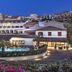 Hotel Corallaro in Santa Teresa Gallura with illuminated pool and hillside village backdrop