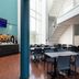 Kyriad Eco Lille Sud - Noyelles Godault dining area with tables, chairs, tall windows and blue columns