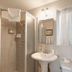 The Tides Laguna Beach bathroom with shower stall, pedestal sink, mirror and window
