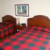 Hostal Bogotá Real in Bogotá: twin room with two plaid-covered beds and a bedside table