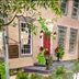 Brick Street Inn in Zionsville exterior with red door, tall windows, and leafy garden plants