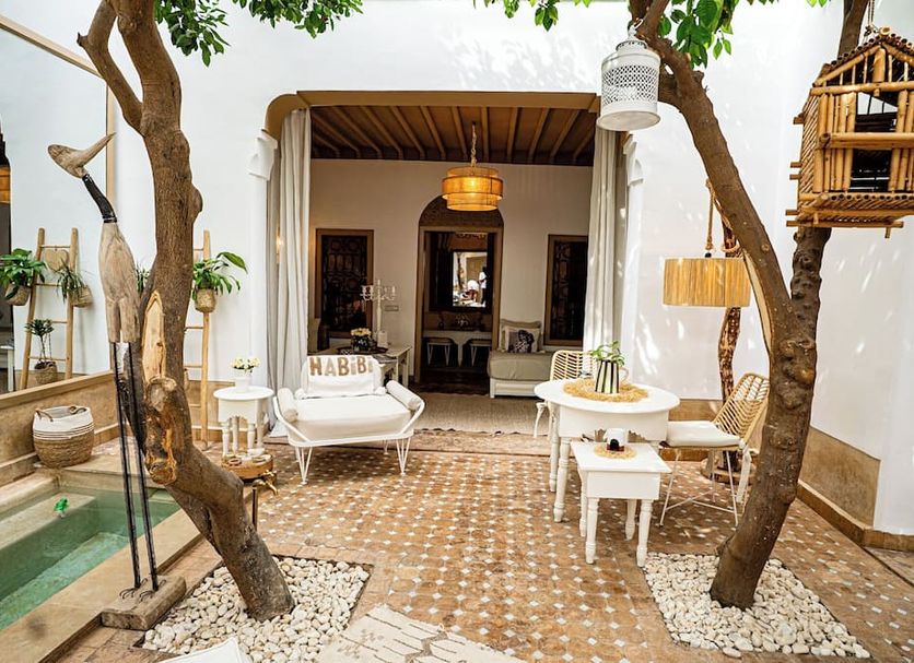 Courtyard at Riad Les Orangers D'Alilia in Marrakech with tree-shaded seating and tiled patio